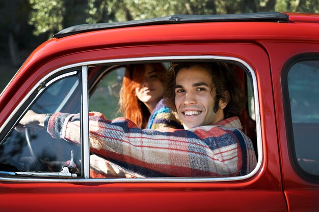 Cerrar pareja sonriente en coche rojo