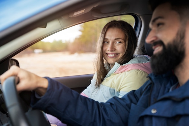 Cerrar pareja sonriente viajando en coche