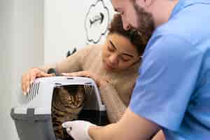 Foto gratuita cerrar personas con lindo gato en la clínica