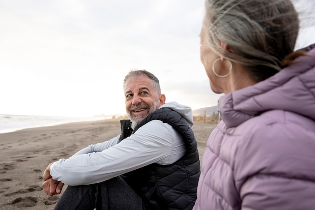 Cerrar personas mayores sentadas en la playa