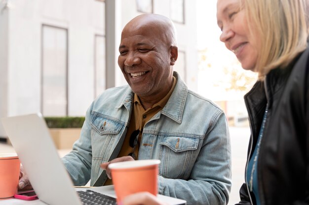 Cerrar personas sonrientes con laptop