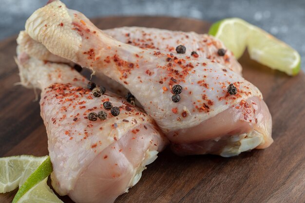 Cerrar las piernas de pollo marinado sobre tabla de madera.