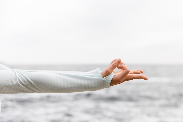 Cerrar la pose de meditación de la mano al aire libre