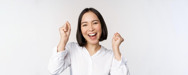 Cerrar el retrato de la cara de una mujer asiática bailando sonriendo triunfando y celebrando con emoción feliz