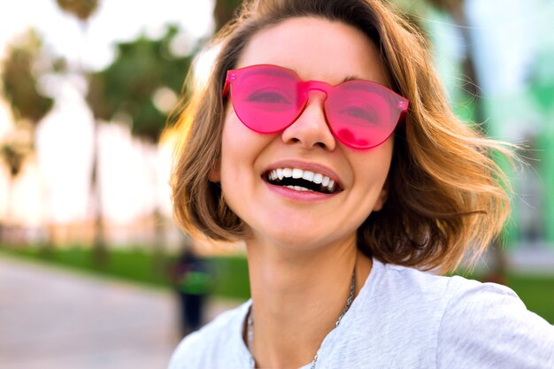 Cerrar retrato positivo de mujer joven alegre sonriendo y riendo, moda positiva