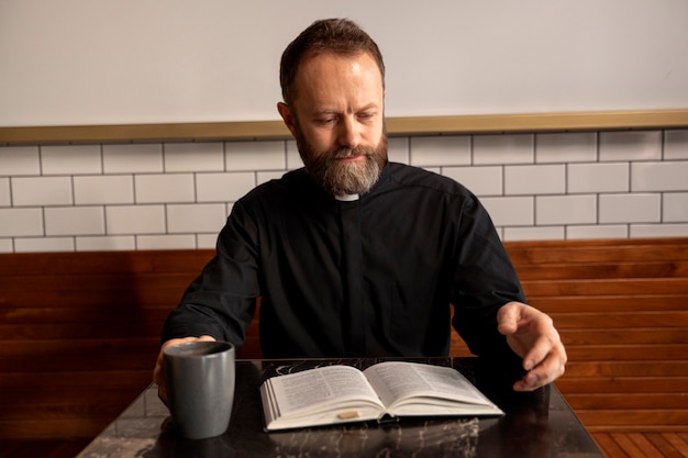 Foto gratuita cerrar el sacerdote leyendo la biblia