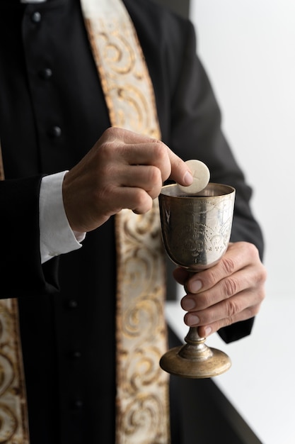 Foto gratuita cerrar sacerdote sosteniendo la eucaristía