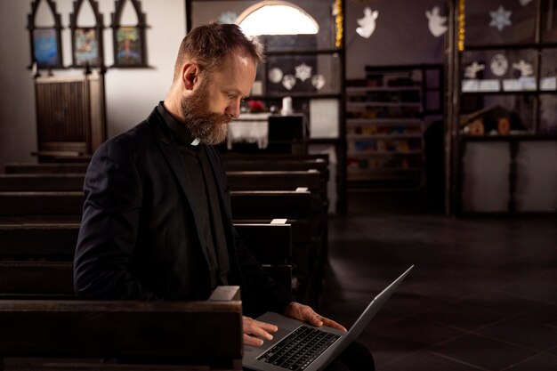 Cerrar en sacerdote usando laptop