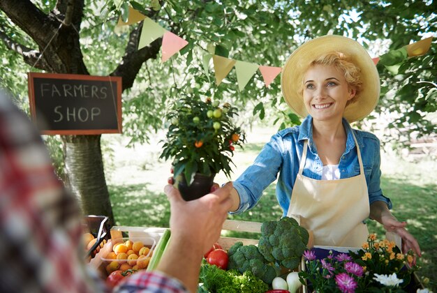 Cerrar sobre mujer vendiendo cultivos de su jardín