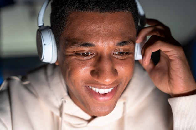 Foto gratuita cerrar sonriente hombre usando audífonos