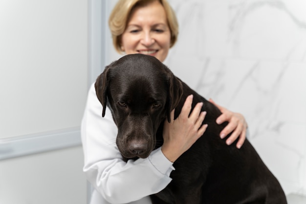 Foto gratuita cerrar sonriente médico sosteniendo perro