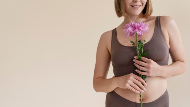 Cerrar sonriente mujer sosteniendo flor