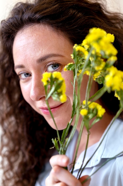 Cerrar sonriente mujer sosteniendo flores