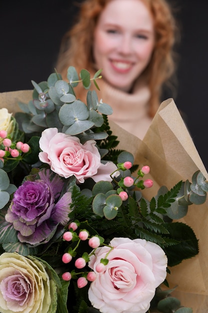 Cerrar sonriente mujer sosteniendo flores