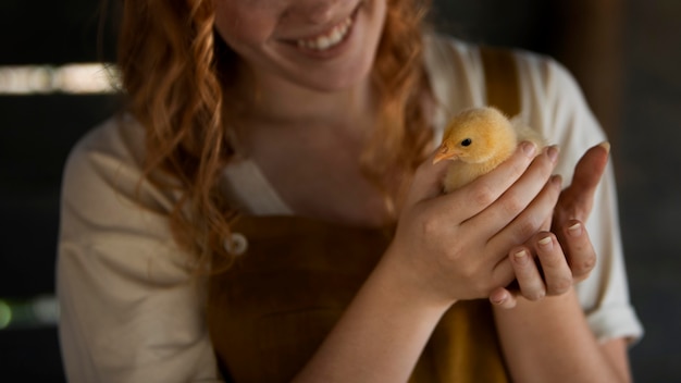 Cerrar sonriente mujer sosteniendo pollo