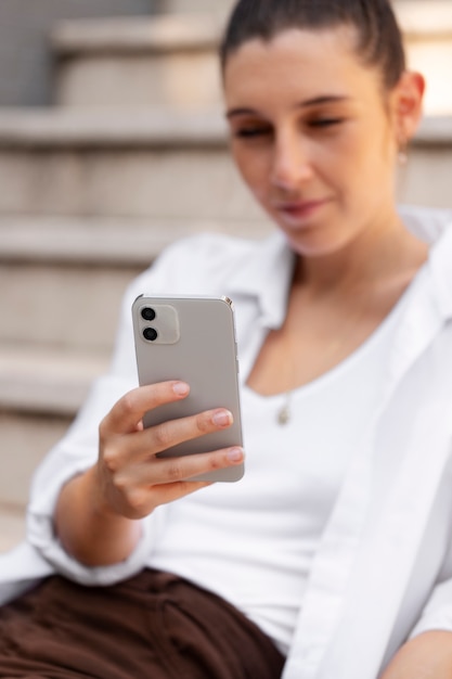 Cerrar sonriente mujer sosteniendo smartphone