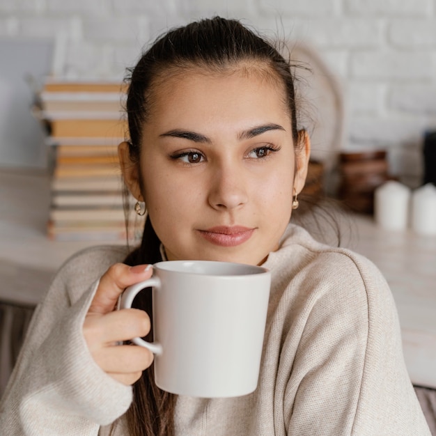 Cerrar sonriente mujer sosteniendo la taza