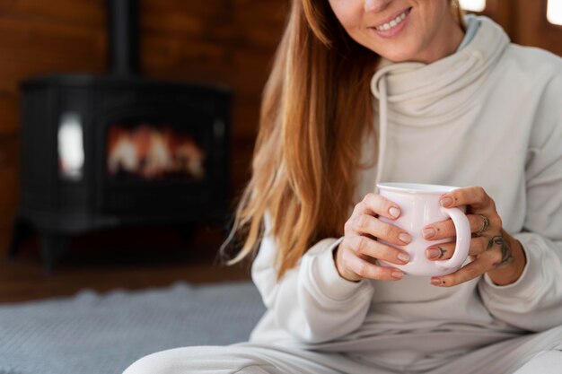 Cerrar sonriente mujer sosteniendo la taza