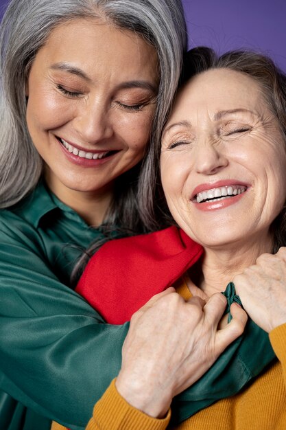 Cerrar sonrientes mujeres mayores abrazándose
