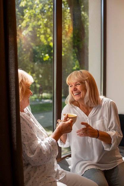 Cerrar sonrientes mujeres sosteniendo tazas