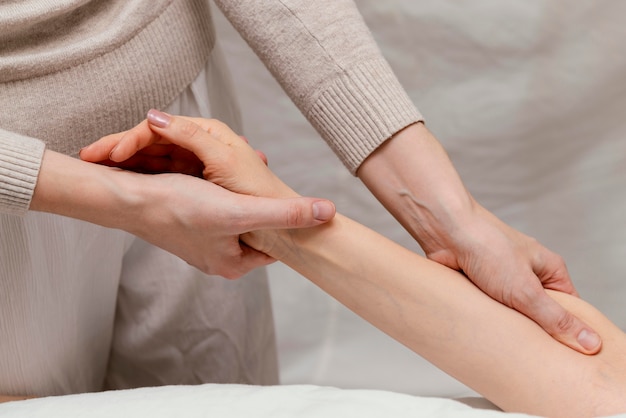 Foto gratuita cerrar terapeuta masajeando el brazo del paciente