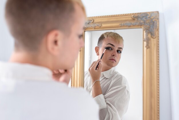 Cerrar transgénero aplicando maquillaje