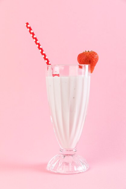 Cerrar vaso de batido de fresa con fondo rosa