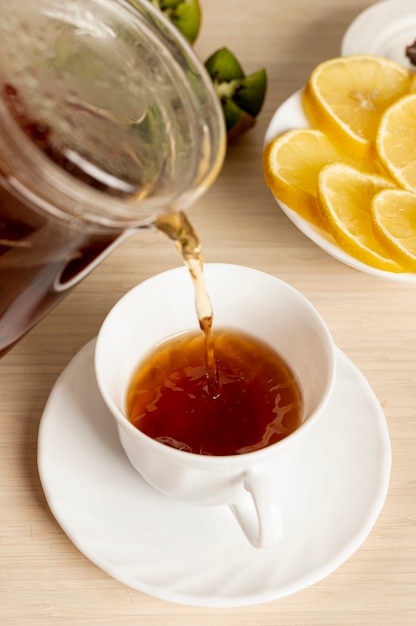 Foto gratuita cerrar vertiendo té en la taza