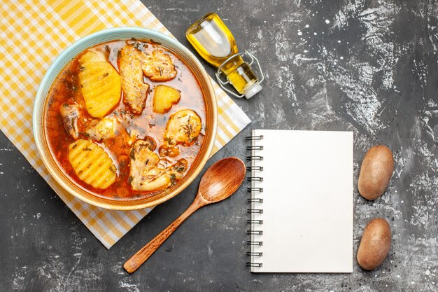 Cerrar vista aérea de sopa de pollo con tomate botella de aceite caído