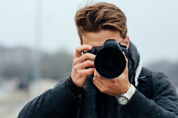 Cerrar vista de fotógrafo profesional tomando fotos al aire libre.