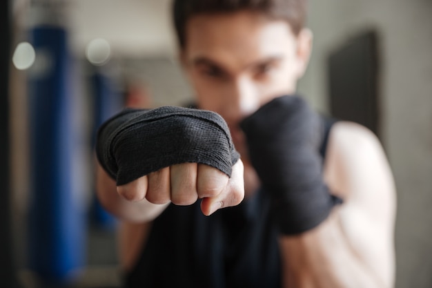Cerrar vista de joven boxeador haciendo ejercicio en el gimnasio