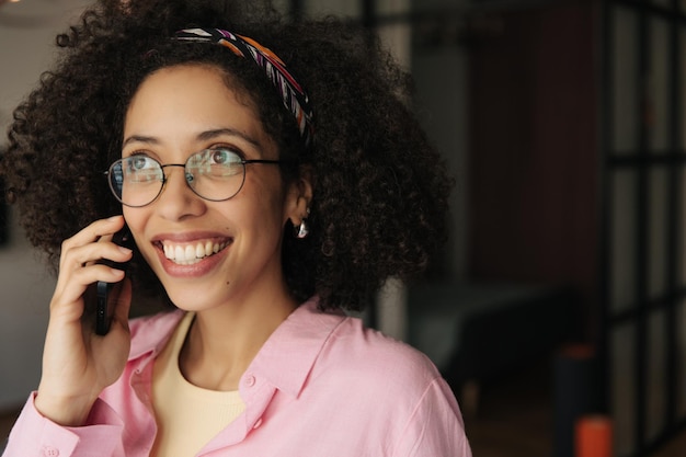 Cerrar vista de mujer negra sonreír y hablar por teléfono