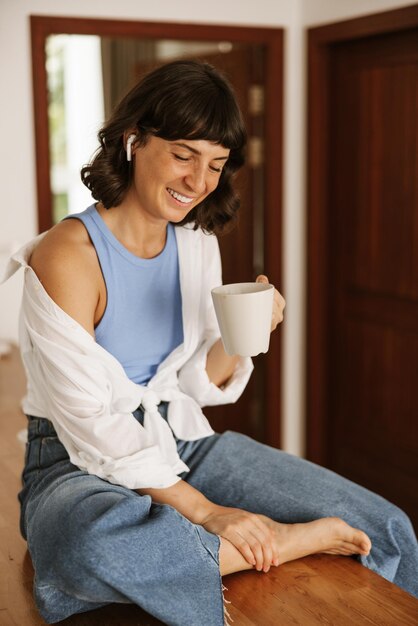 Cerrar vista de mujer sonriente sosteniendo café en la mano