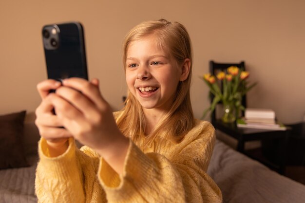 Cerrar vista de niña sonriente mirando el teléfono