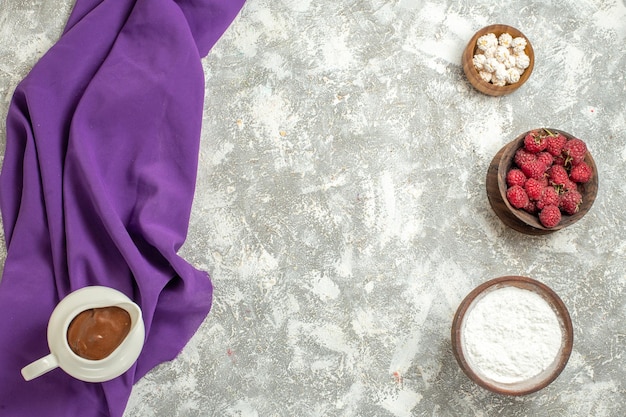 Foto gratuita cerrar vista superior de una jarra de chocolate con cuencos de complementos dulces sobre un fondo de mármol