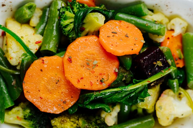 Cerrar vista superior verduras guisadas zanahorias espárragos con brócoli en un plato