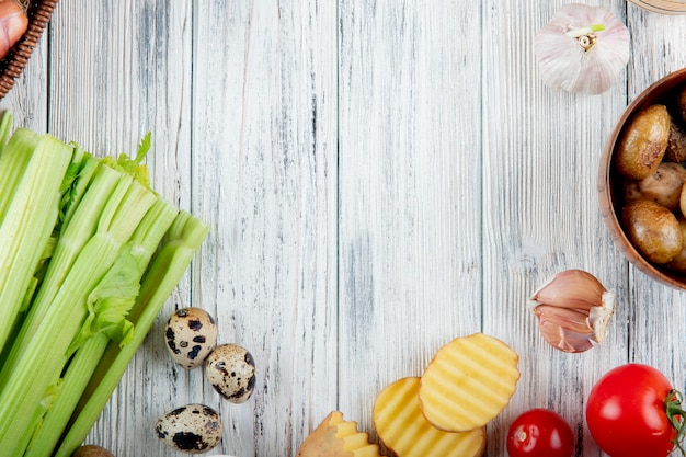 Cerrar vista de verduras como apio huevo patata ajo tomate sobre fondo de madera con espacio de copia