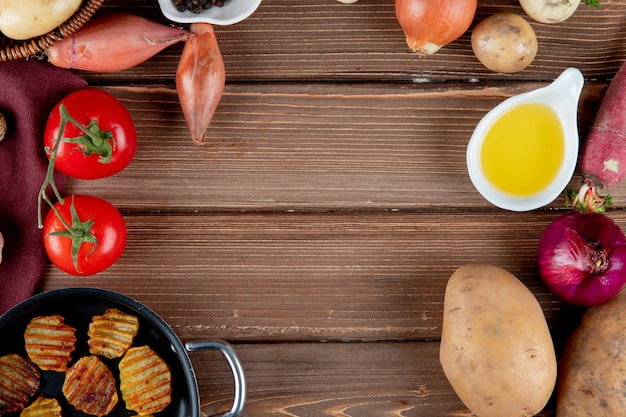 Cerrar vista de verduras como tomate cebolla patata con mantequilla y papas fritas sobre fondo de madera con espacio de copia