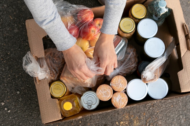 Foto gratuito cerrar voluntario y comida en caja.