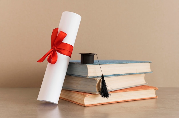 Certificado de diploma de educación y pequeño sombrero de graduación.