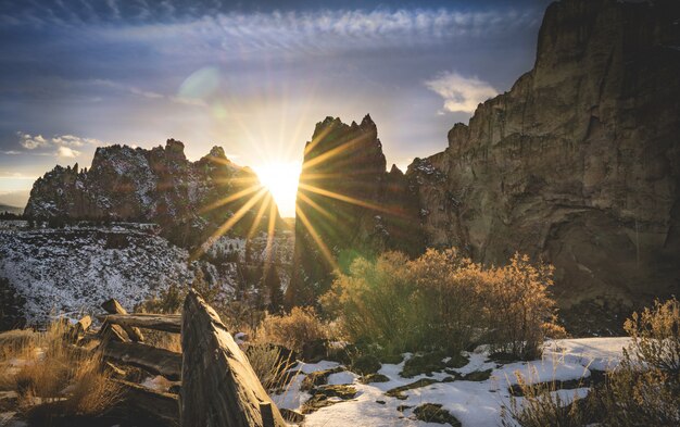 Césped cubierto de nieve cerca de cañones durante el atardecer