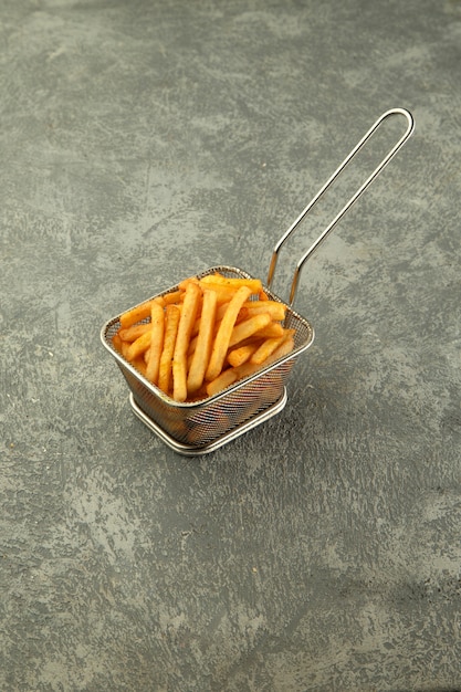 Foto gratuita cesta de acero de papas fritas sobre fondo gris liso