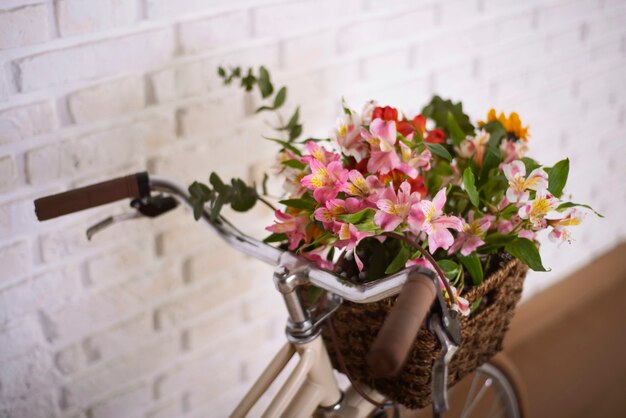 Cesta de bicicleta con hermosas flores de alto ángulo.