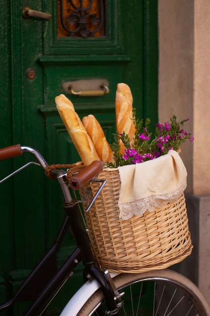 Cesta de bicicleta de vista lateral con baguette y flores.