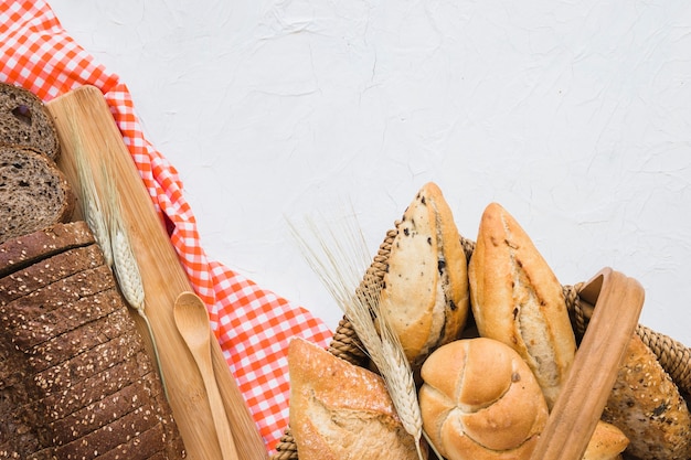 Foto gratuita cesta con bollos cerca de pan y tela