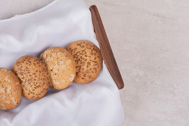 Cesta de galletas con semillas de sésamo sobre superficie blanca.