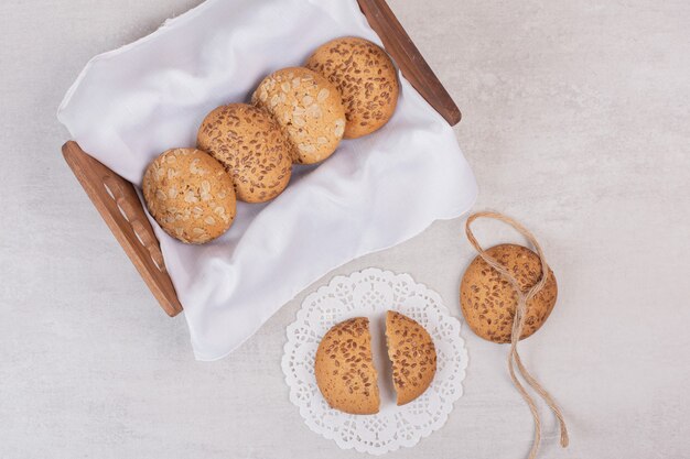 Cesta de galletas con semillas de sésamo sobre superficie blanca.