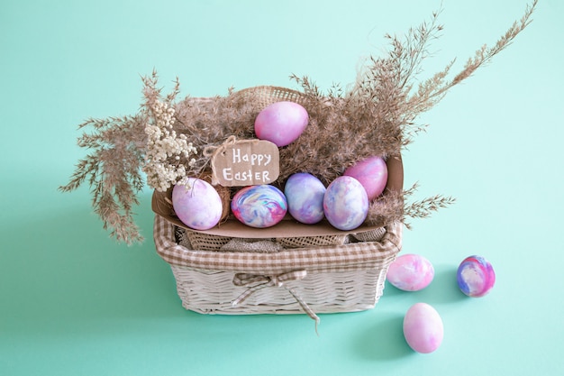 Cesta con los huevos de Pascua en un fondo aislado coloreado.