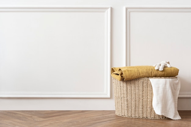 Foto gratuita cesta de lavandería de ratán en una habitación blanca