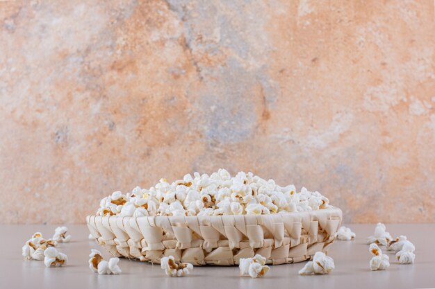 Cesta de mimbre de palomitas de maíz saladas para la noche de cine sobre fondo blanco. Foto de alta calidad